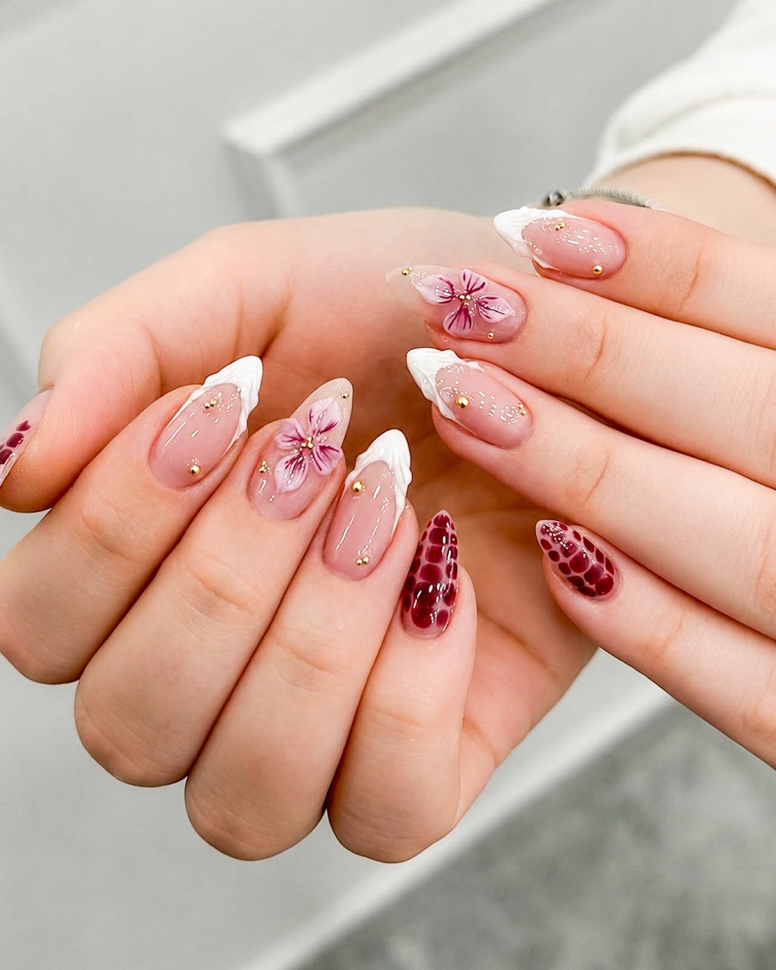 Pink blossom nail art with burgundy accent nails by My Royal Nails & Spa in Humble, TX